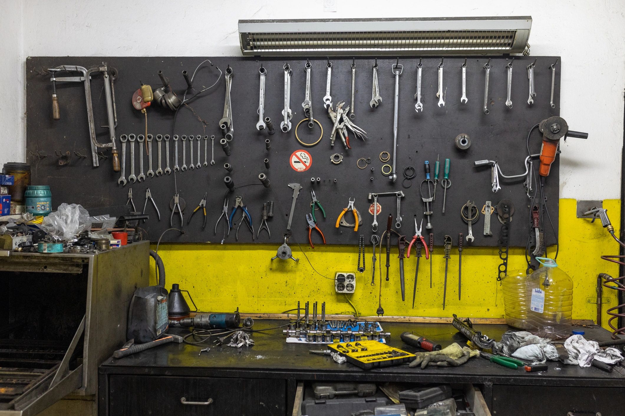 Various tools hanging on the wall in workshop.
