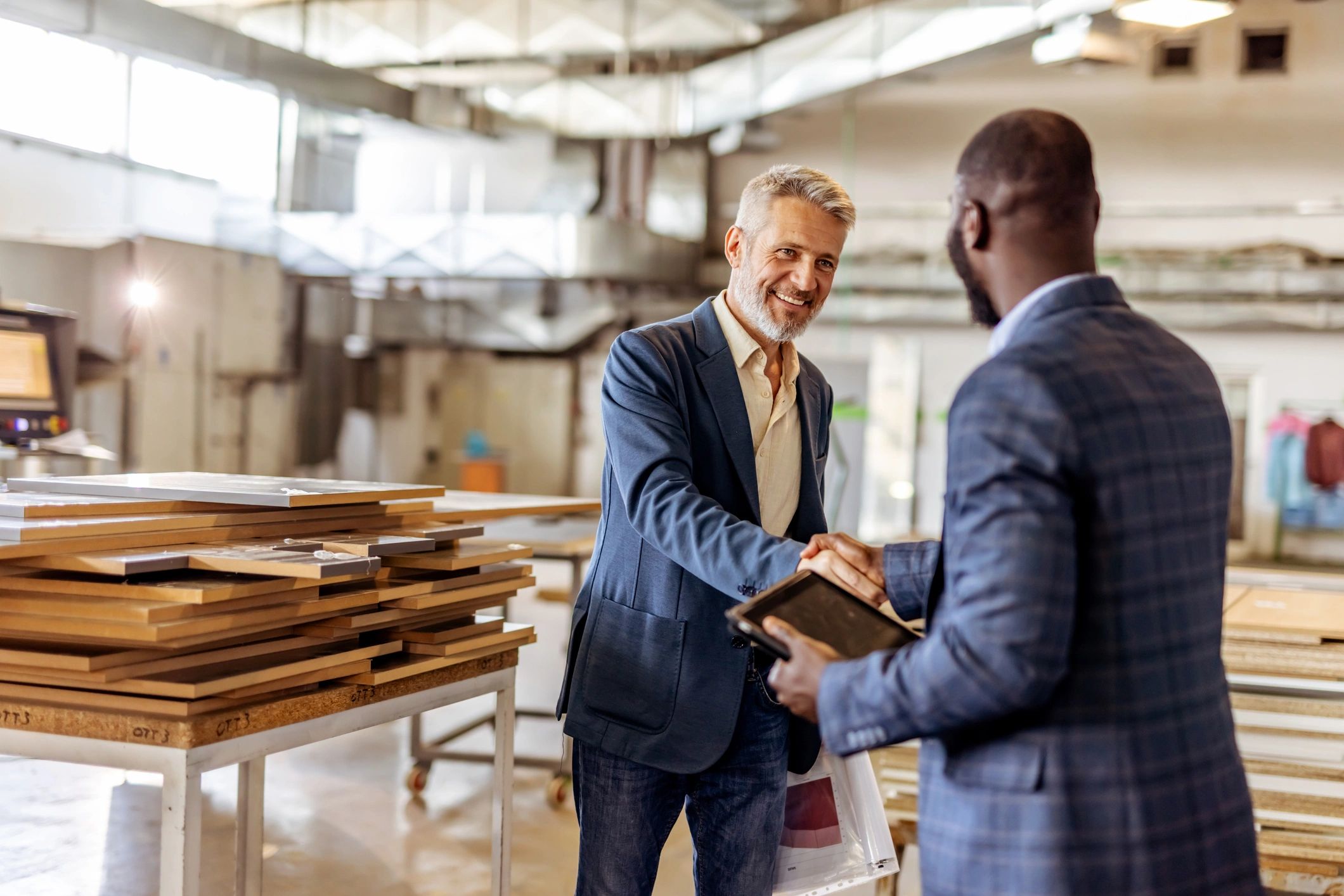 Professionals shaking hands in a modern industrial workshop